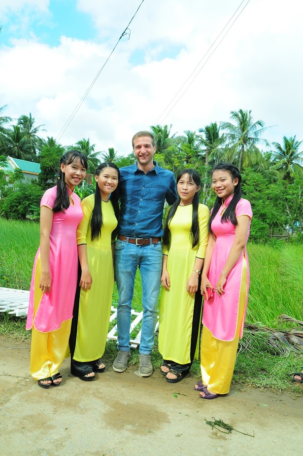westerner posing with Vietnamese in ao dai