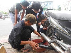 Tire guy fixing flat tire by dipping innertube in water trying to find holes